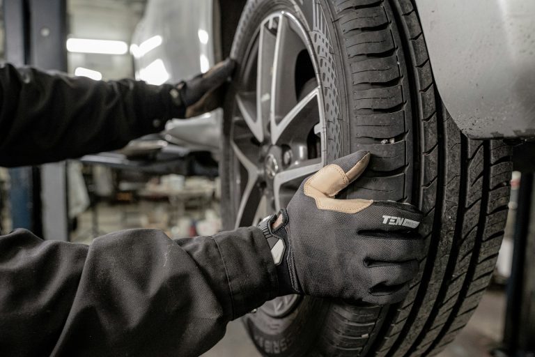 jimmy-nilsson-masth-9uHal2Dd9aE-unsplash A man working on a tire in a garage