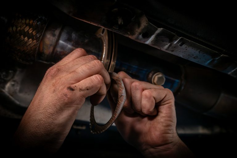 martin-fennema-nwSGKWYE9cM-unsplash A man working on a cars engine with a wrench